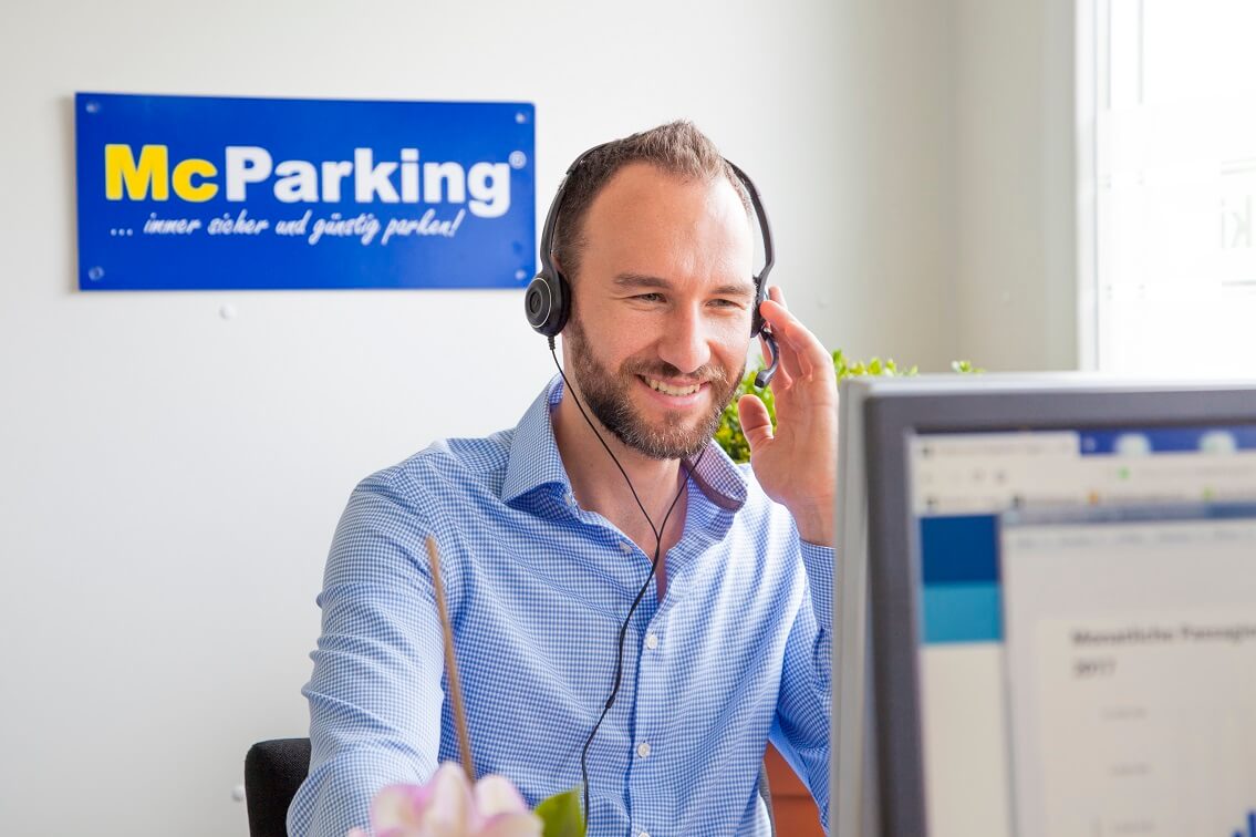 Mitarbeiter mit Headset am Telefon Unsere McParking-Mitarbeiter helfen Ihnen weiter