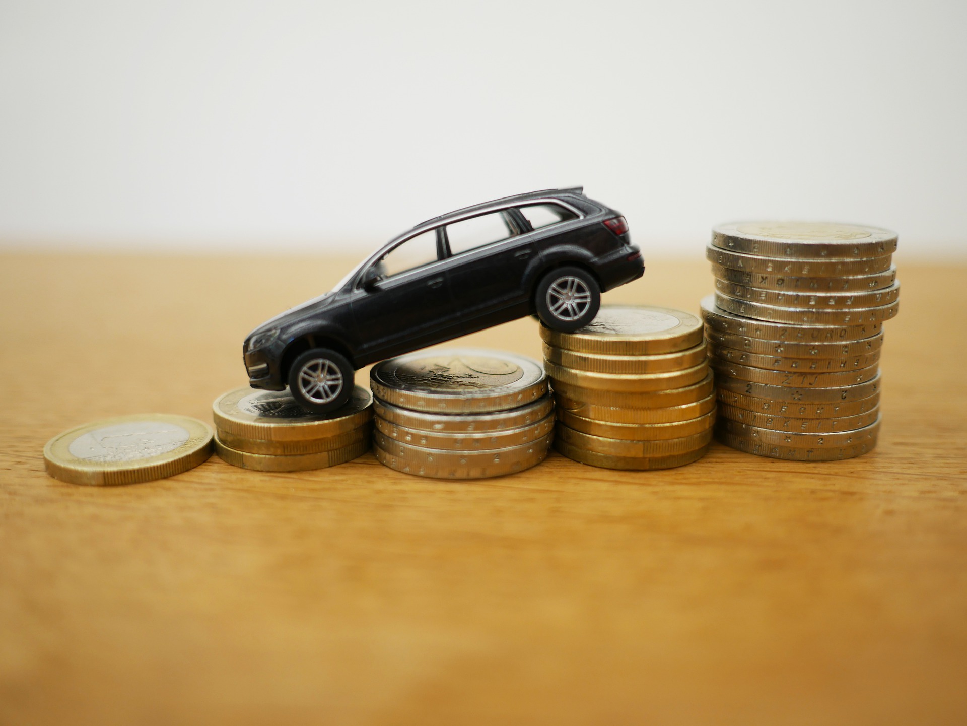 Toy car on euro coins - Car purchase thanks to small VAT?