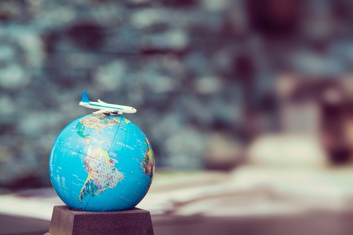Globus mit Spielflugzeug - Wieder in den Urlaub reisen & parken bei McParking