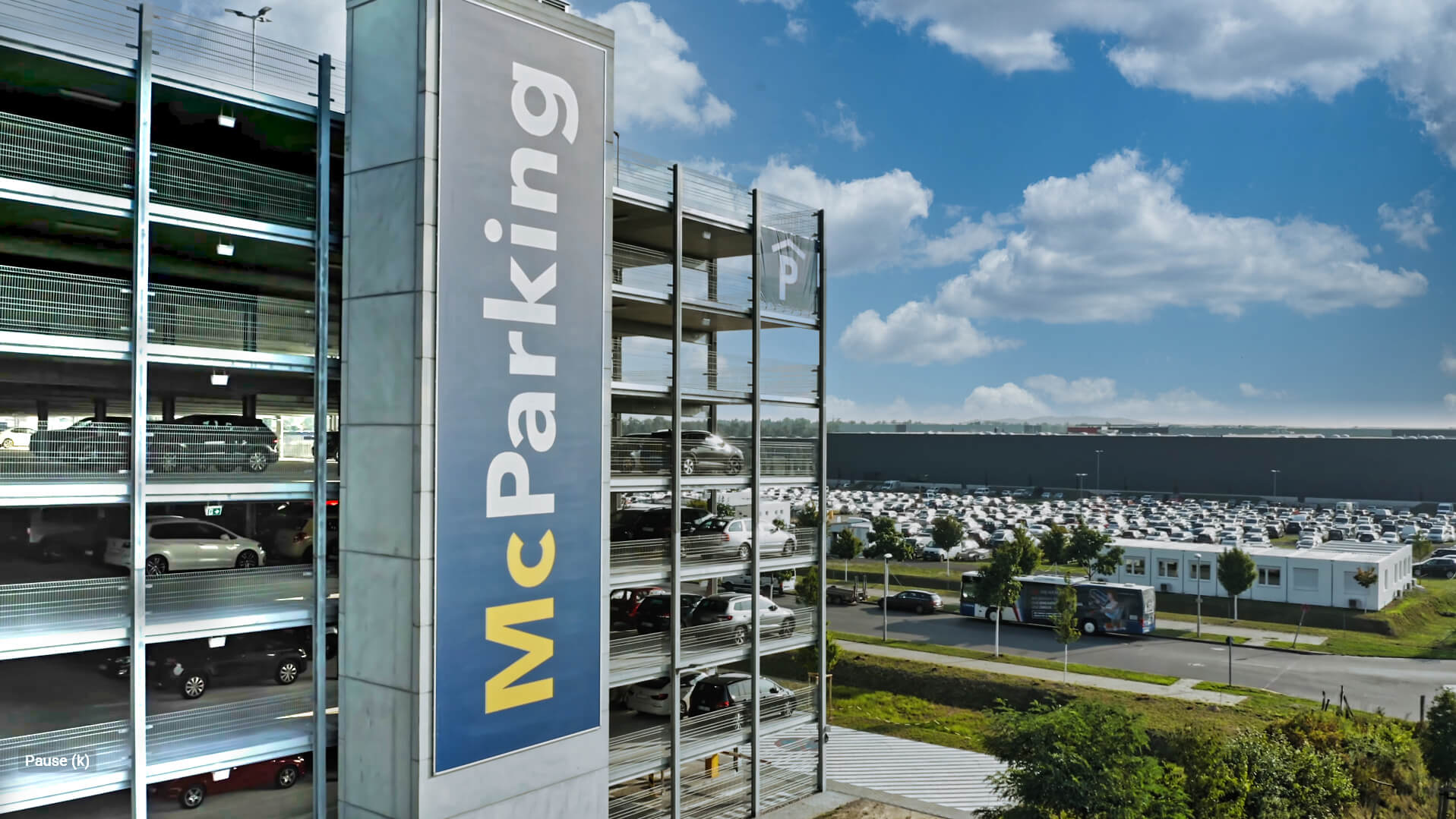 Parken Ber im Parkhaus von McParking – Parken Berlin Flughafen Parken am Ber - McParking Parkhaus von außen mit großem McParking Banner